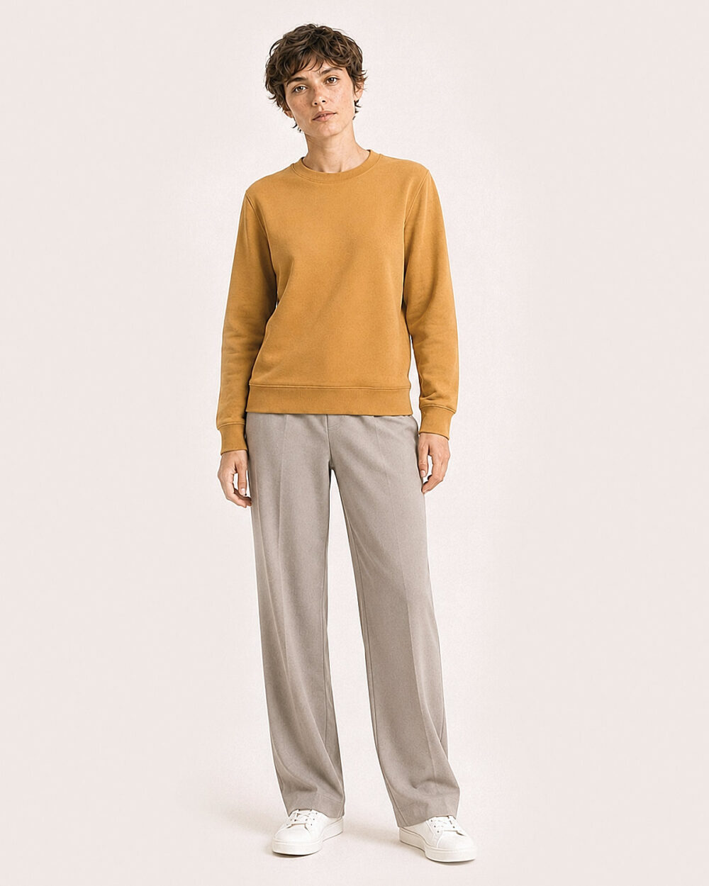 Model Weiblich trägt das BILLOW Sweatshirt von CALYPSO GIANO in Ochre in einer entspannten Pose.