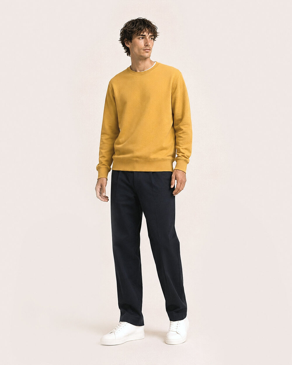 Model Männlich trägt das BILLOW Sweatshirt von CALYPSO GIANO in Ochre in einer entspannten Pose.