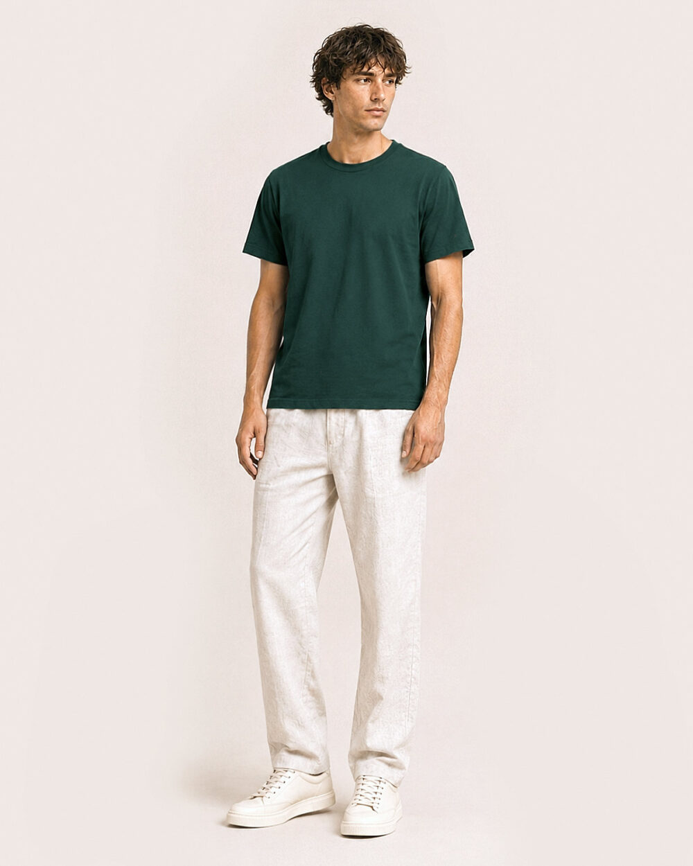 Model M2 trägt das SENSE T-Shirt von CALYPSO GIANO in Grün in einer entspannten Pose.