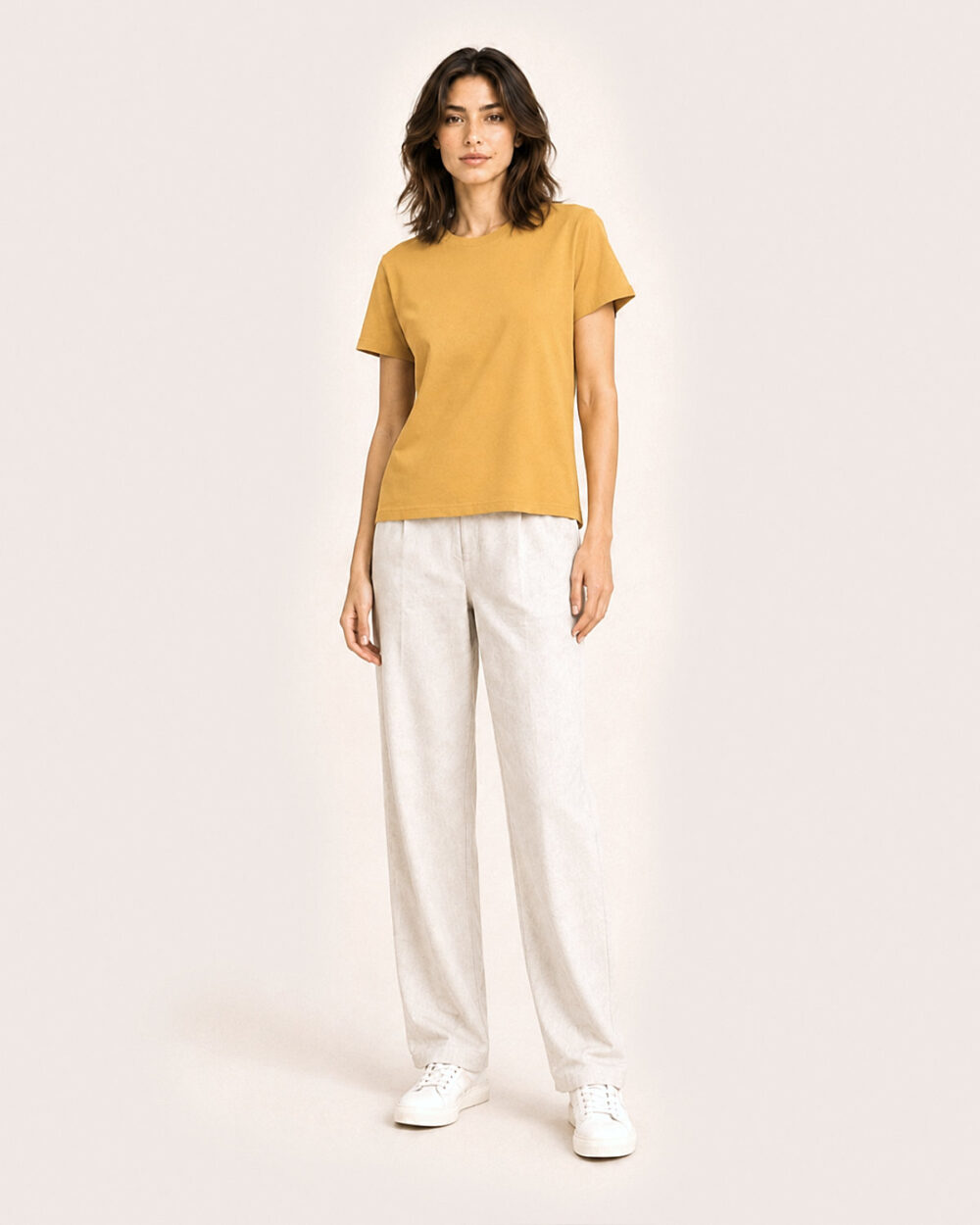 Model F2 trägt das SENSE T-Shirt von CALYPSO GIANO in Ochre in einer entspannten Pose.