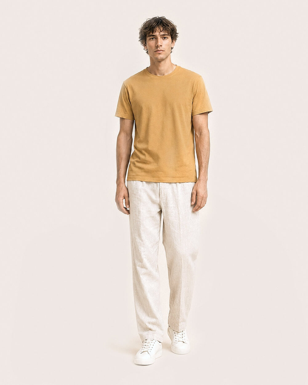 Model M2 trägt das SENSE T-Shirt von CALYPSO GIANO in Ochre in einer entspannten Pose.