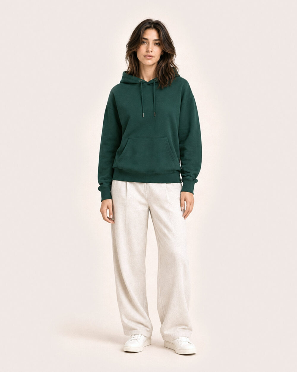Model F2 trägt den WAVE Hoodie von CALYPSO GIANO in Grün in einer entspannten Pose.