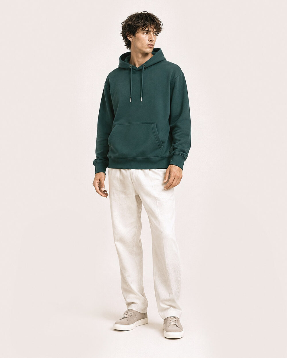 Model M2 trägt den WAVE Hoodie von CALYPSO GIANO in Grün in einer entspannten Pose.