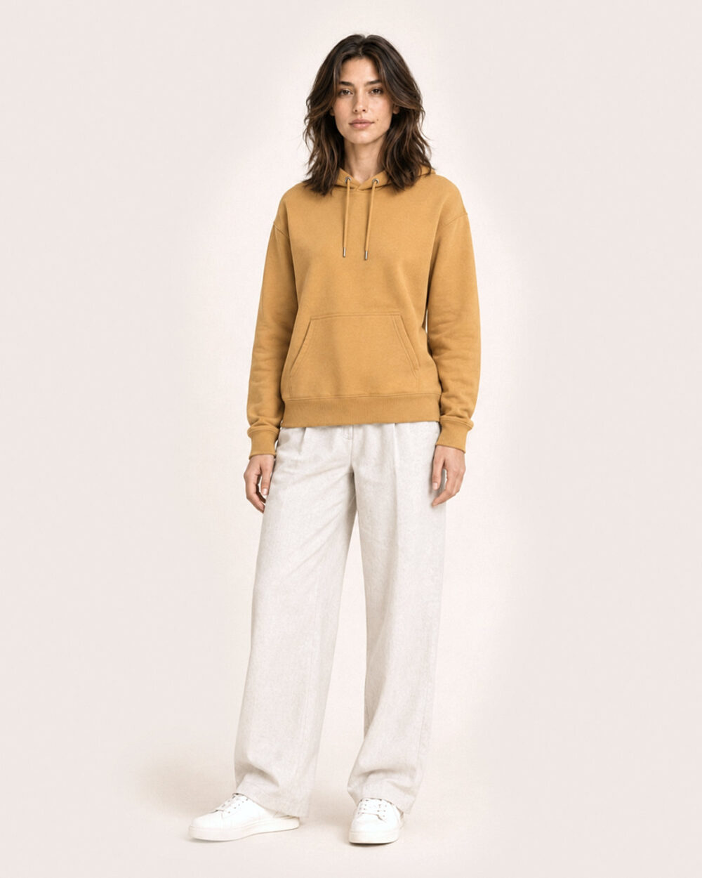 Model F2 trägt den WAVE Hoodie von CALYPSO GIANO in Ochre in einer entspannten Pose.