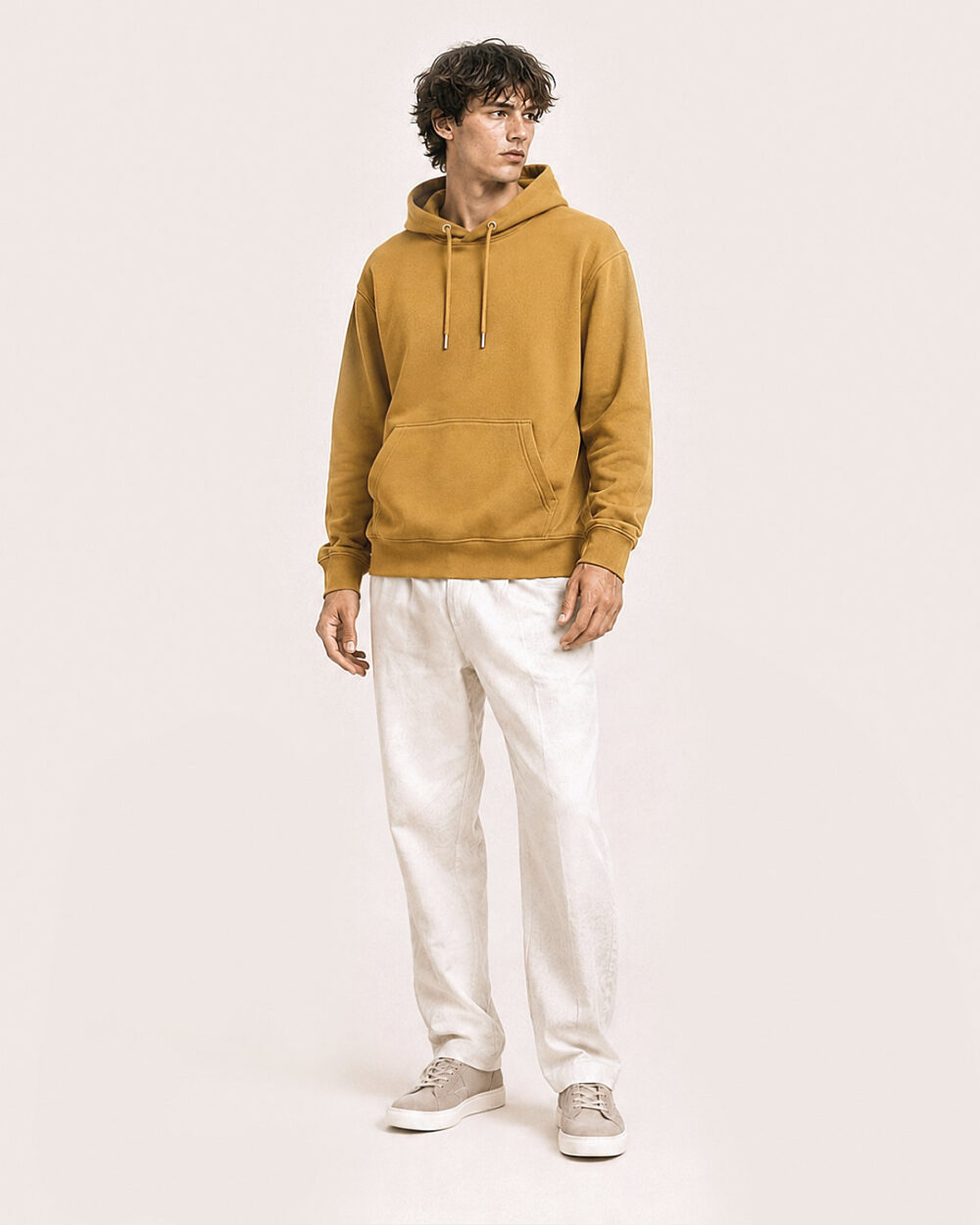 Model M2 trägt den WAVE Hoodie von CALYPSO GIANO in Ochre in einer entspannten Pose.
