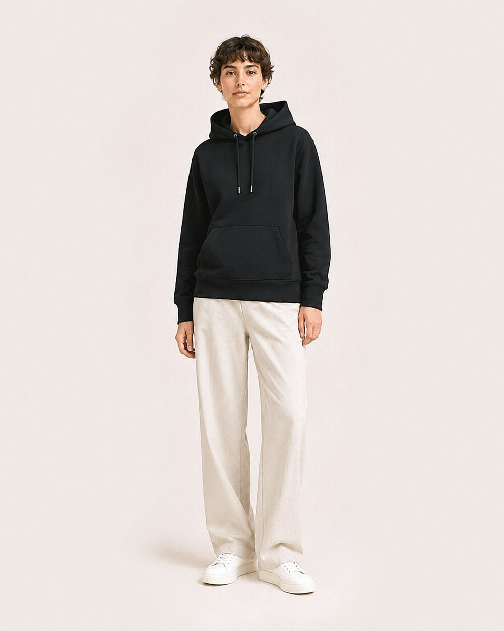 Model F3 trägt den WAVE Hoodie von CALYPSO GIANO in Schwarz in einer entspannten Pose.