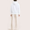 Model F3 trägt den weissen WAVE Hoodie von CALYPSO GIANO in der Rückenansicht.